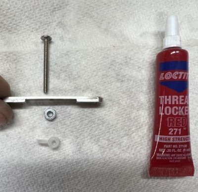 Remove the long bolt from the end and install into the center in the orientation shown, the jam nut is secured and tightened after the long bolt is tight.  I use red loctite for this.  Lastly install the flag matching the direction of the arrow.
