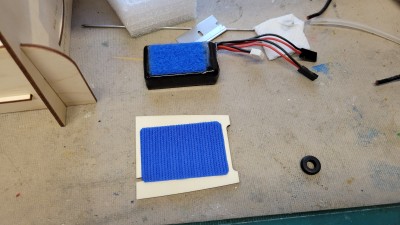 I place the velcro on top of the battery plate with CA before gluing the plate in.